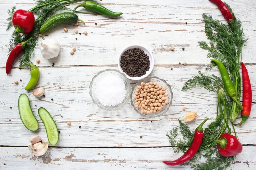pickles-white-wooden-table-with-green-red-chili-peppers-fennel-salt-black-peppercorns-garlic-pea-close-up-healthy-concept-top-view-flat-lay
